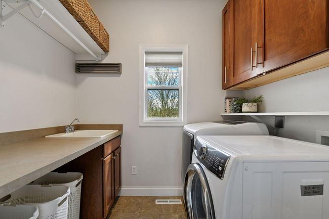 Main floor laundry with sink located off of the mudroom. | Image 16