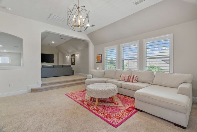 Living room with carpet floors, baseboards, plenty of natural light, a chandelier, and vaulted ceiling | Image 30