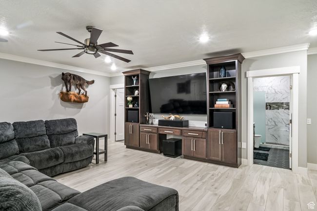 Living area with ceiling fan, crown molding, light wood finished floors, and recessed lighting | Image 61