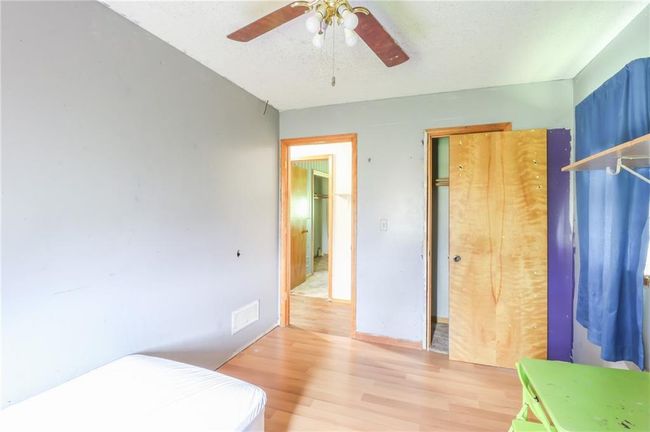 Bedroom with light wood-style floors and a ceiling fan | Image 12