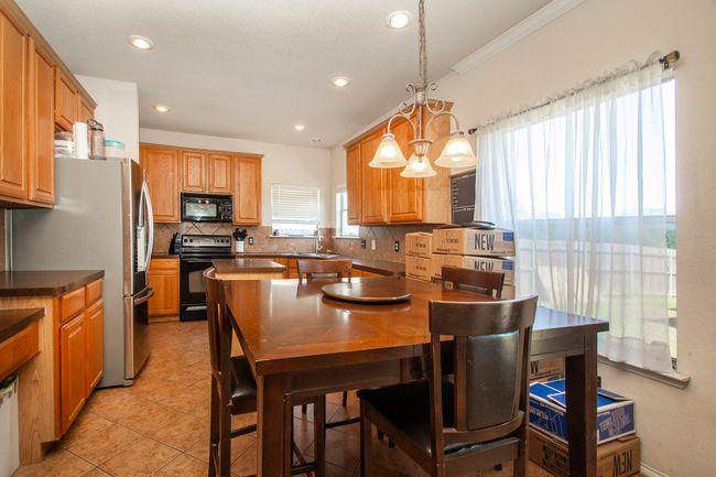Kitchen featuring black appliances, a sink, backsplash, crown molding, and recessed lighting | Image 11