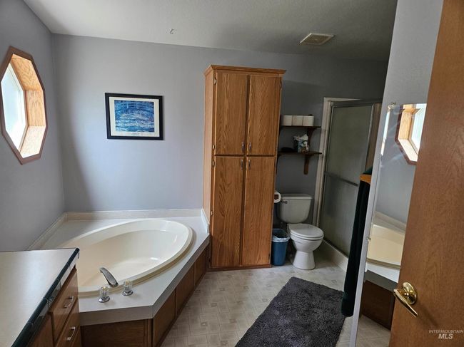Full bathroom with a garden tub, a shower stall, and vanity | Image 11