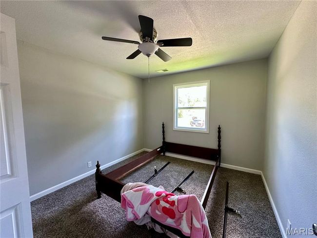 Exercise room featuring carpet floors, a ceiling fan, and a textured ceiling | Image 8