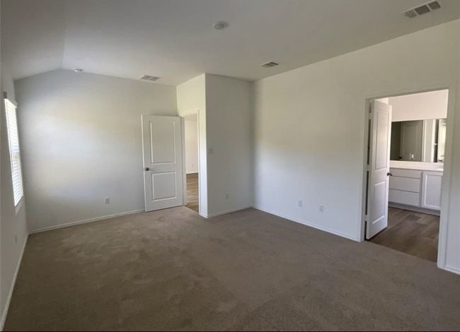 Unfurnished bedroom with carpet flooring, lofted ceiling, baseboards, and ensuite bath | Image 25