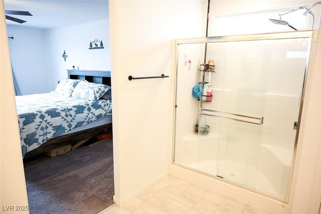 Full bath with baseboards, a ceiling fan, tile patterned flooring, a shower stall, and connected bathroom | Image 25