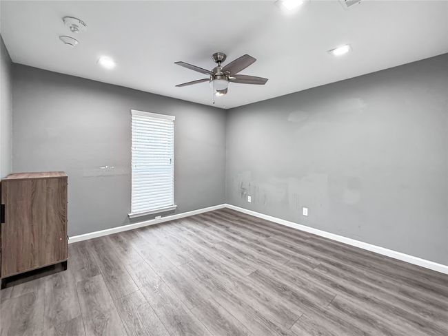 Spare room featuring wood finished floors, a ceiling fan, and a smoke detector | Image 19