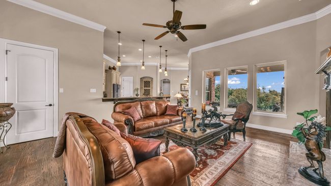 Living room featuring a ceiling fan, crown molding, wood finished floors, baseboards, and recessed lighting | Image 8