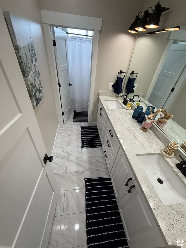 Bathroom featuring baseboards, marble finish floor, a sink, and double vanity | Image 64