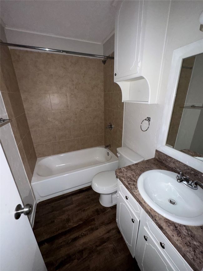 Full bathroom with vanity, tub / shower combination, toilet, and wood finished floors | Image 15