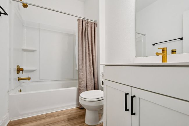 Full bathroom featuring shower / bath combo with shower curtain, wood finished floors, and vanity | Image 11