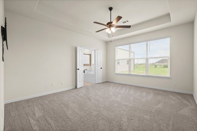 Spare room with light colored carpet, a ceiling fan, and a tray ceiling | Image 14