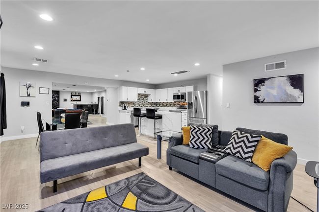 Living area featuring visible vents, light wood finished floors, and recessed lighting | Image 7