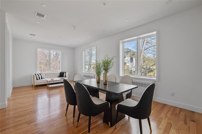 Dining space with radiator, baseboards, light wood-style floors, and visible vents | Image 19
