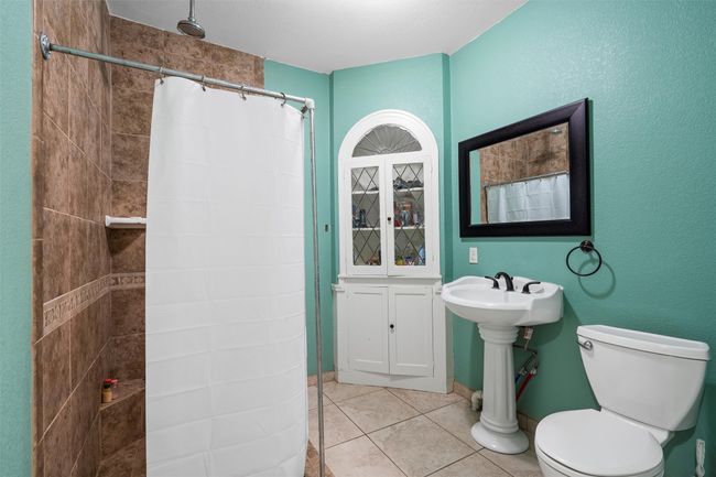 Bathroom featuring tiled shower and tile patterned flooring | Image 16