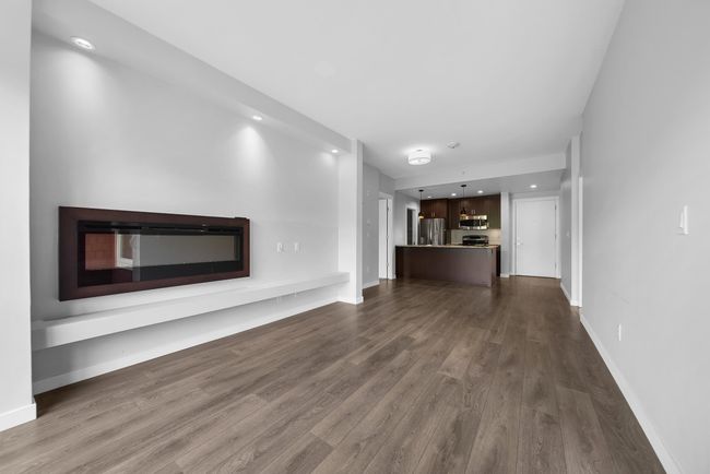 Unfurnished living room featuring dark wood-style flooring, a fireplace, and baseboards | Image 23