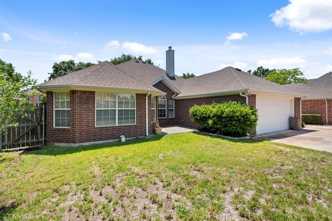 Single story home with brick siding, concrete driveway, a chimney, a garage, and roof with shingles | Image 39