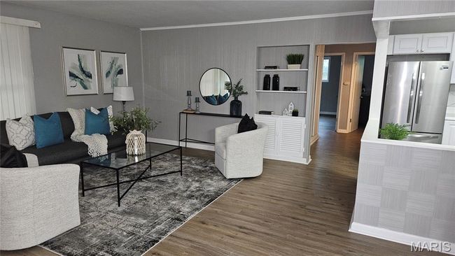 Living room featuring wood finished floors and crown molding | Image 7