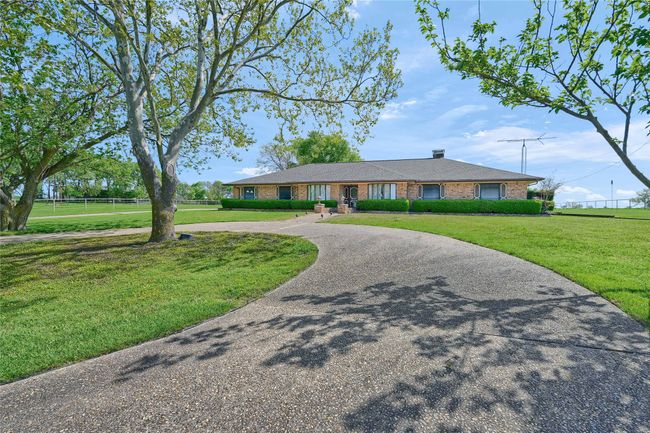 Single story home with a front yard, brick siding, and curved driveway | Image 5