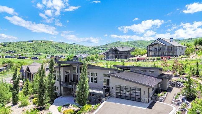 View of front facade with a mountain view, stone siding, a residential view, and asphalt driveway | Image 103
