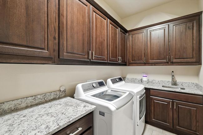 Laundry area featuring cabinet space, separate washer and dryer, and light tile patterned floors | Image 18