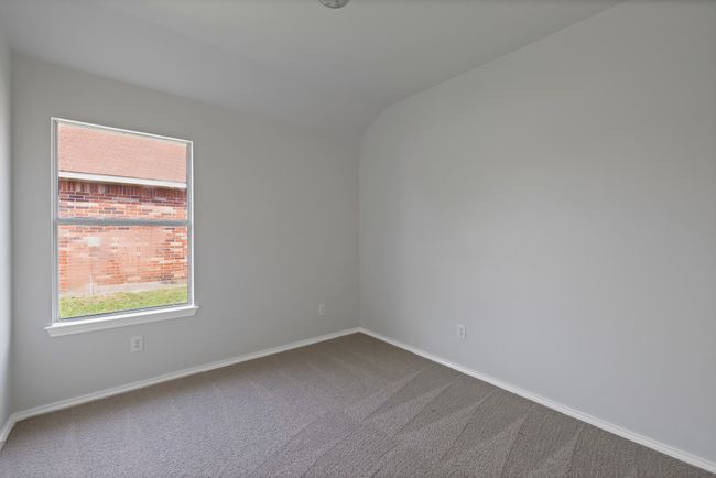 Unfurnished room featuring carpet, baseboards, and lofted ceiling | Image 12