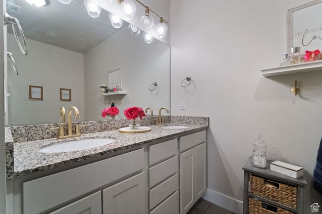 Bathroom with double vanity, tile patterned floors, baseboards, and a sink | Image 17
