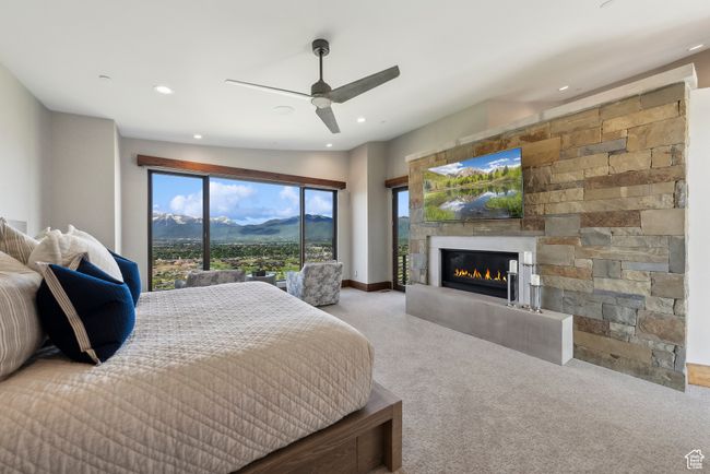 Bedroom featuring carpet flooring, recessed lighting, a glass covered fireplace, multiple windows, and a ceiling fan | Image 43