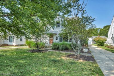 Obstructed view of property with a front lawn and a shed | Image 1