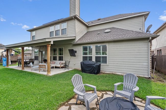 Rear view of property featuring an outdoor hangout area, a patio, a chimney, and a shingled roof | Image 37