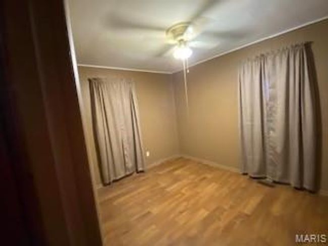 Spare room featuring light wood-style flooring, a ceiling fan, and baseboards | Image 5