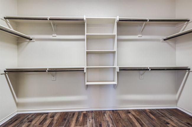 Walk in closet featuring dark wood-style flooring | Image 23