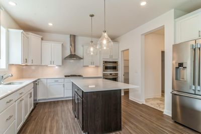 Photo is of the actual home. Soft close drawers and doors, undercabinet lighting, double oven, outside vented hood and 5-burner gas cooktop are just a few of the in-demand features of this kitchen. | Image 3