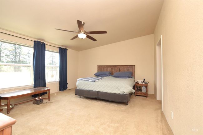 Bedroom with light colored carpet, vaulted ceiling, and a ceiling fan | Image 14