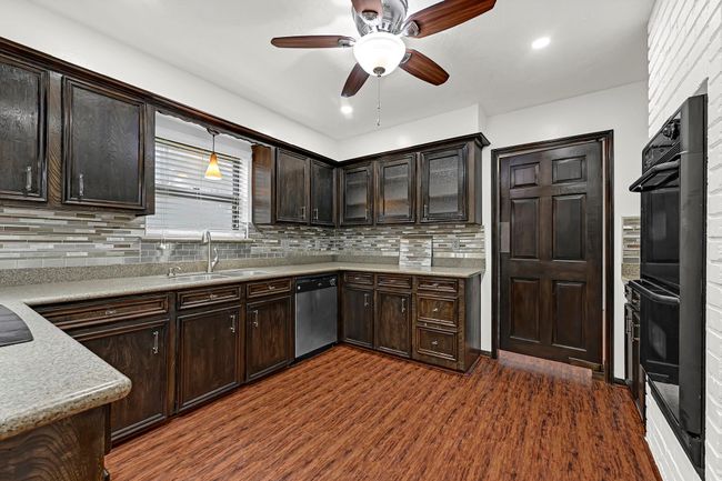 This kitchen features amply cabinentry space, granite counter tops, and even room to add a center island. | Image 19