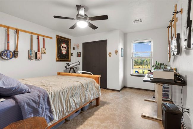 Bedroom with baseboards, visible vents, and ceiling fan | Image 18