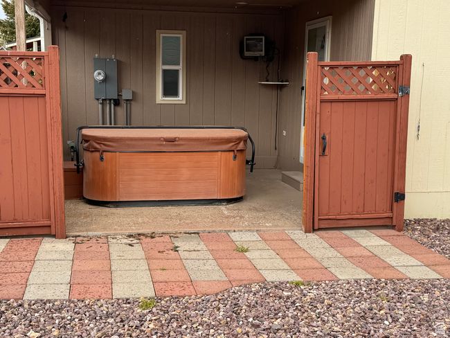View of patio / terrace featuring a hot tub and a gate | Image 25