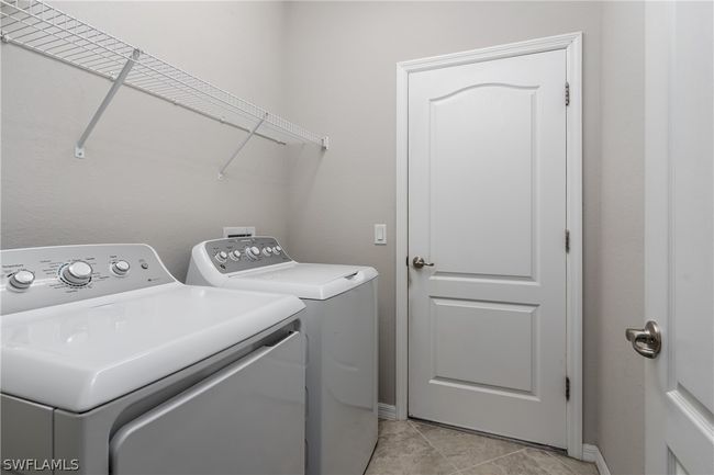 Laundry room featuring light tile floors and washing machine and dryer | Image 27