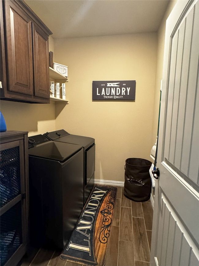 Laundry area with washer and clothes dryer, cabinet space, and wood finish floors | Image 26