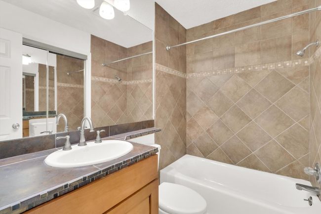 Full bath featuring toilet, vanity, and washtub / shower combination | Image 23