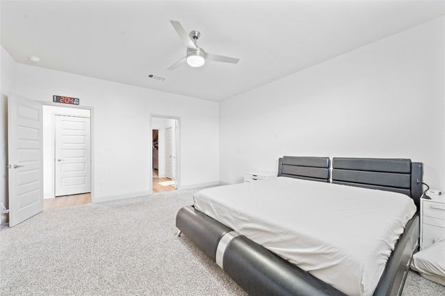 Carpeted bedroom featuring visible vents, baseboards, and a ceiling fan | Image 21