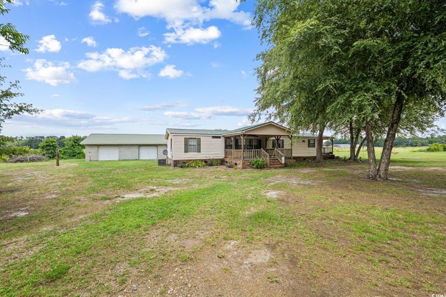 View of front of home featuring covered porch, a detached garage, an outbuilding, and a front lawn | Image 30