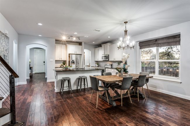 Dining space with arched walkways, dark wood-style floors, recessed lighting, and a chandelier | Image 16
