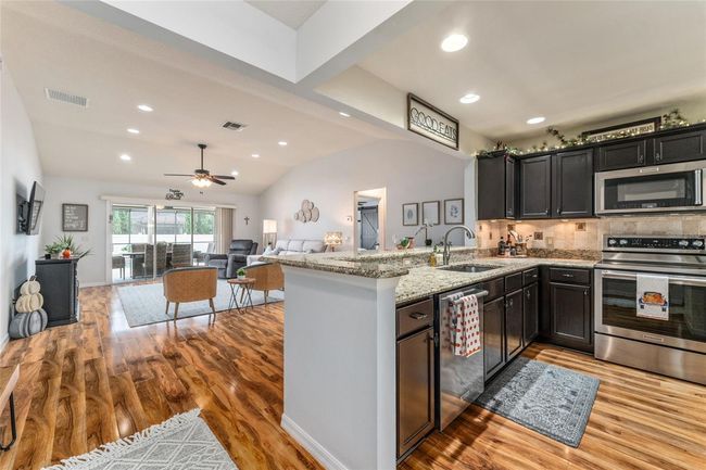 Nicely updated interior with laminate flooring throughout, additional ceiling lighting, lighted ceiling fans and granite counters | Image 4