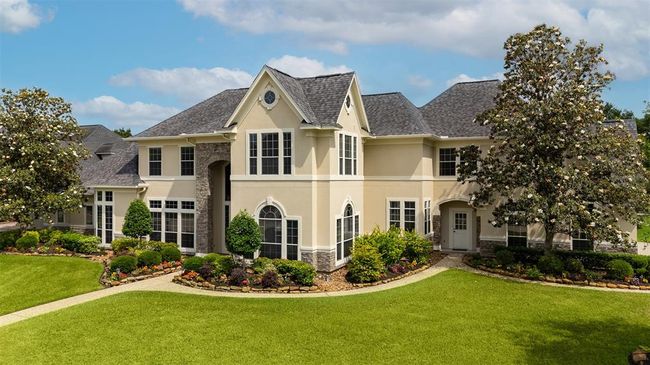 This home’s facade stuns from every angle. A combination of stone, stucco, and elegant architectural lines is enhanced by lush, meticulously maintained landscaping that adds warmth and curb appeal all year long. | Image 9