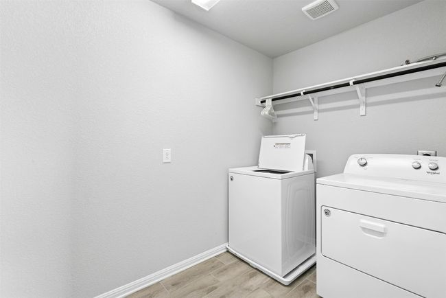 Washroom featuring washing machine and clothes dryer and light wood-style floors | Image 18