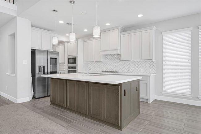 Gourmet kitchen with plenty of storage space. Soft closing drawers. Deep sink. Water filtration included. Gas stove. Stainless steel appliances. There is additional storage space in the kitchen island. | Image 9