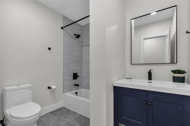 Full bath with toilet, baseboards, vanity, tile patterned flooring, and shower combination | Image 16