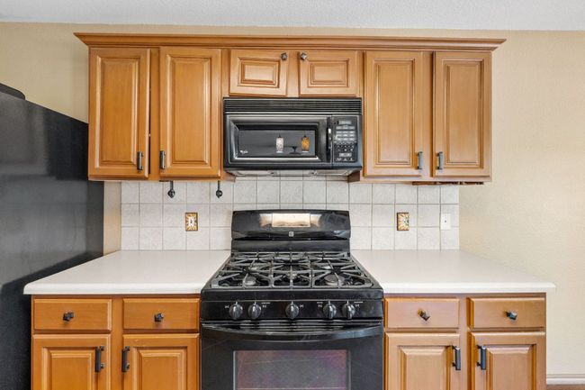Kitchen featuring black appliances, light countertops, and tasteful backsplash | Image 11