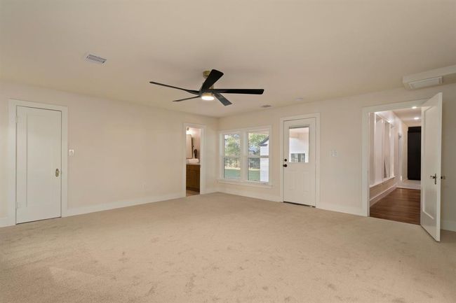 Large windows bring in plenty of natural light, while a modern 52" ceiling fan with light kit illuminates this relaxing space. | Image 19
