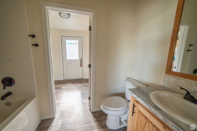 Bathroom with toilet, vanity, wood finished floors, and baseboards | Image 12
